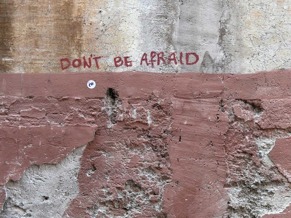 A wall with graffiti saying 'Don't be afraid'